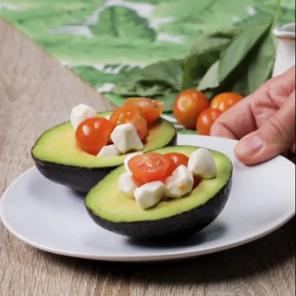3 Easy 3-Ingredient Meals That Saved My Sanity (You'll Actually Want to Make These Tonight!) 25 Hands preparing caprese stuffed avocado with fresh mozzarella and tomatoes