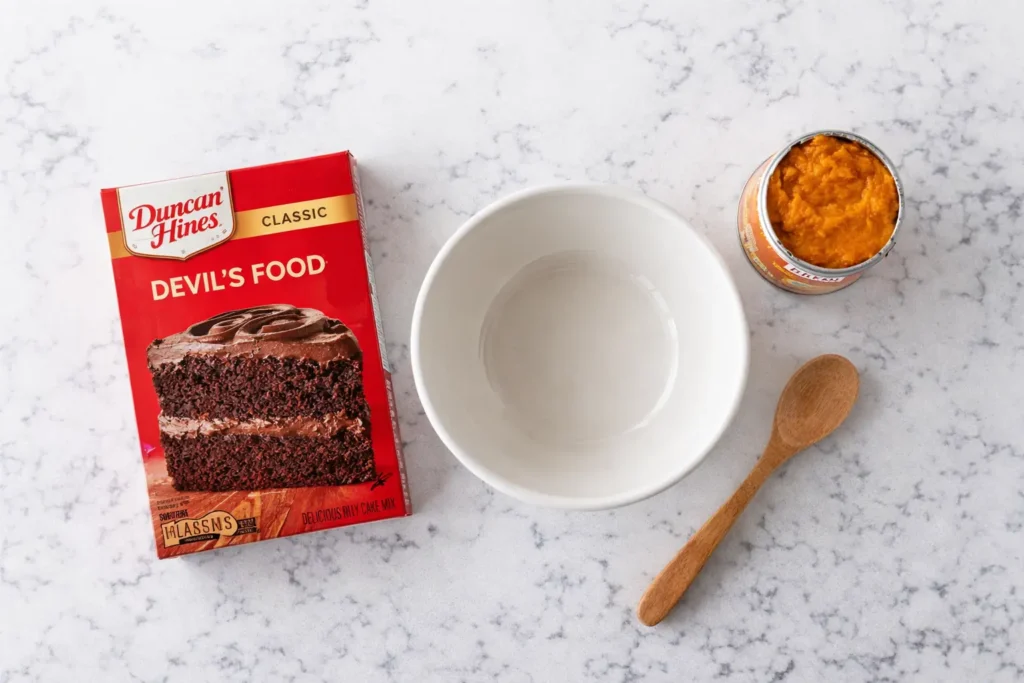2 Ingredient Chocolate Bread – Easy, Budget-Friendly, Ready in 30 Minutes 8 Two ingredients for chocolate bread recipe - Duncan Hines chocolate cake mix box and Libby's pumpkin puree can on white counter