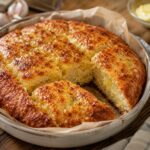 Golden carnivore garlic bread with one slice cut, showing soft interior